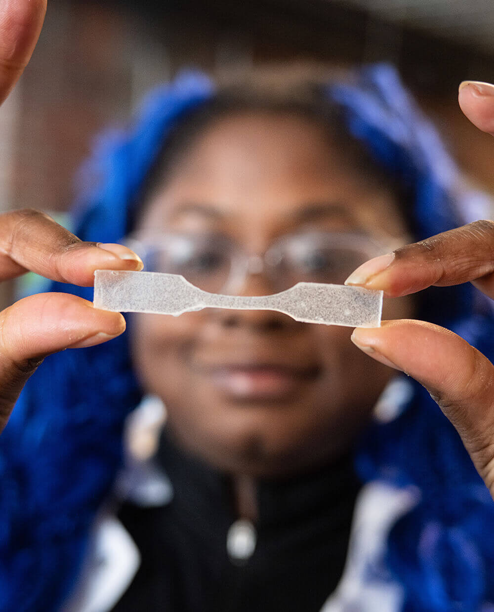 A Greentown founder holding up a material test sample in the lab