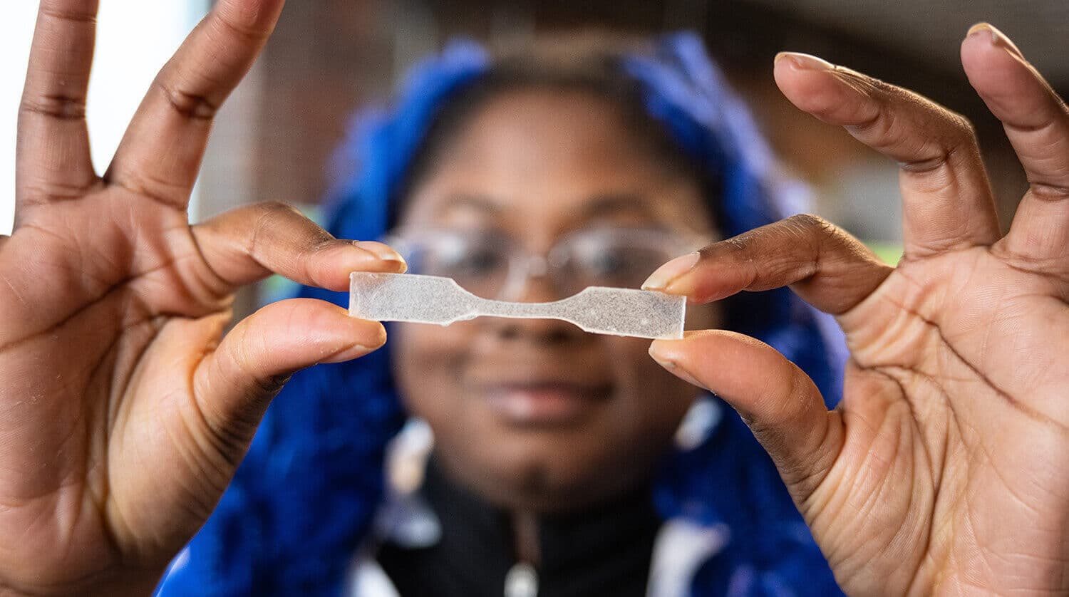 A Greentown founder holding up a material test sample in the lab